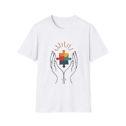 White t-shirt with colorful puzzle piece design held by hands on a white background